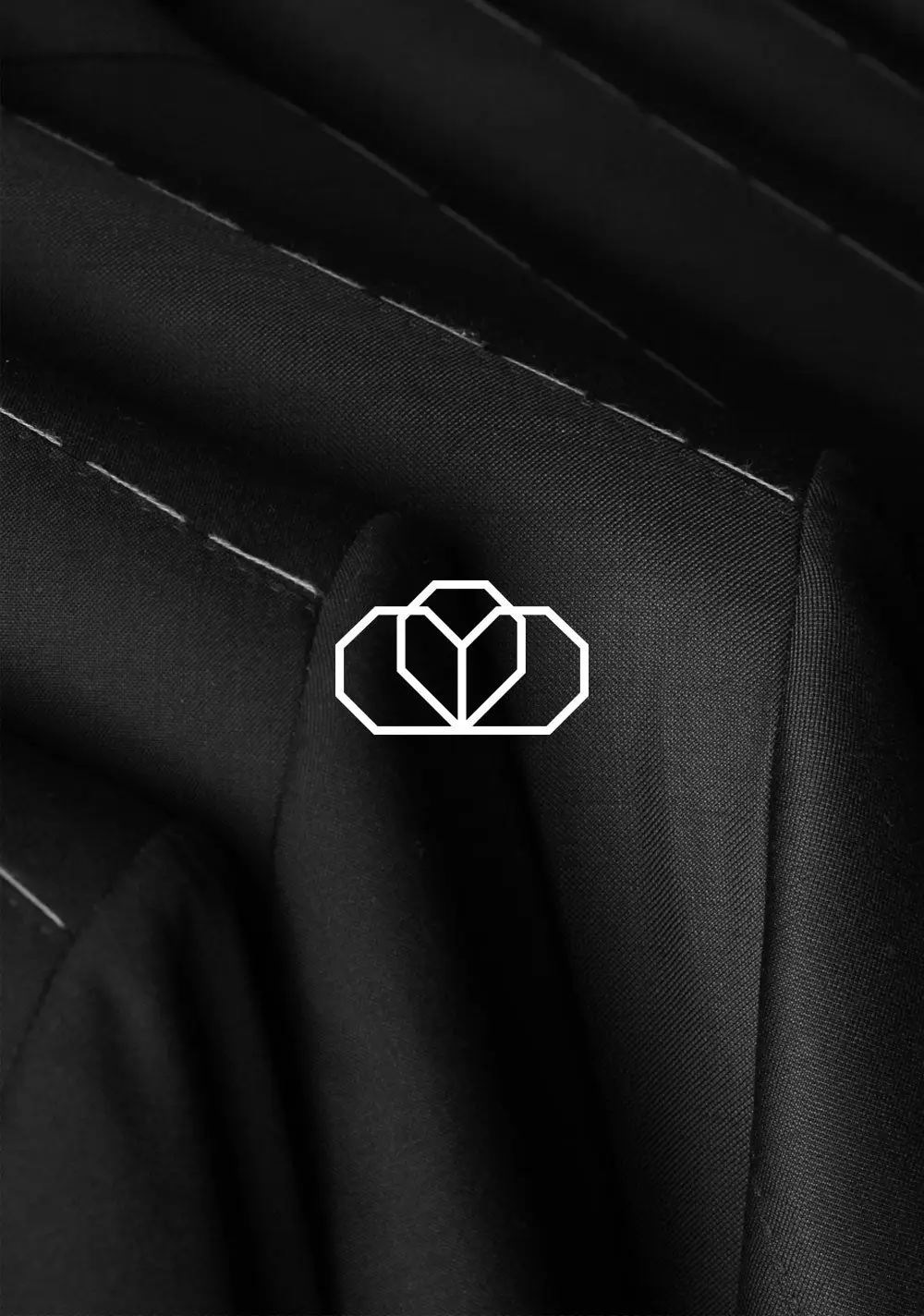 Costume Limité crown emblem stitched on dark tailoring fabric